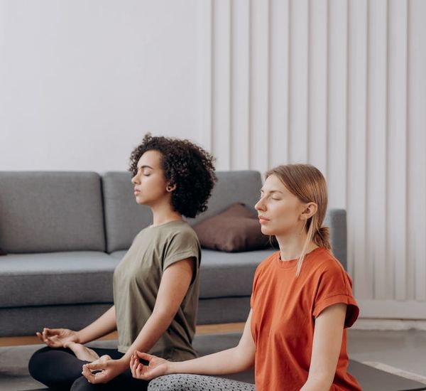 A person sitting in a serene meditation pose in a bright, peaceful room.